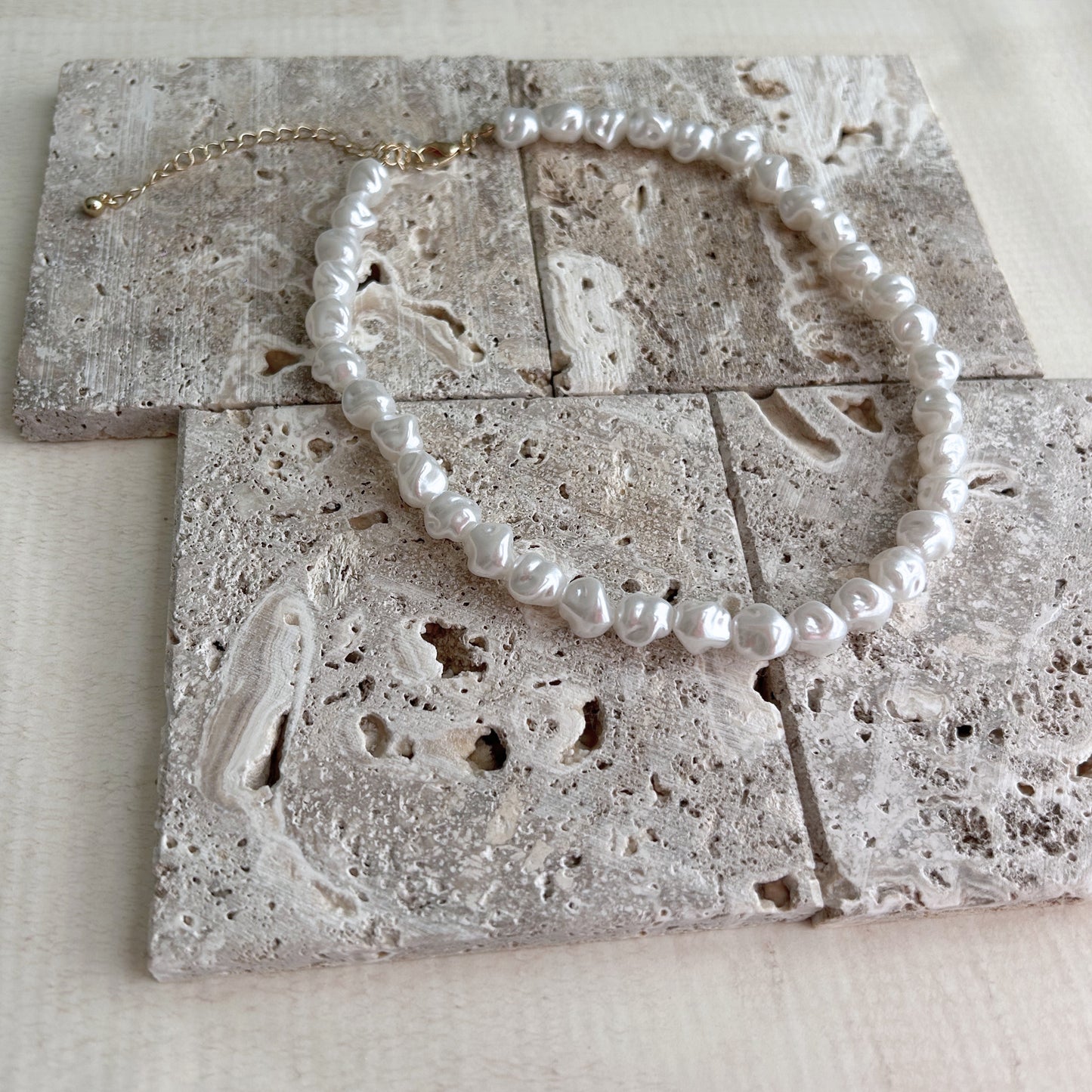 Circular jewelry pieces placed on natural textured stone blocks