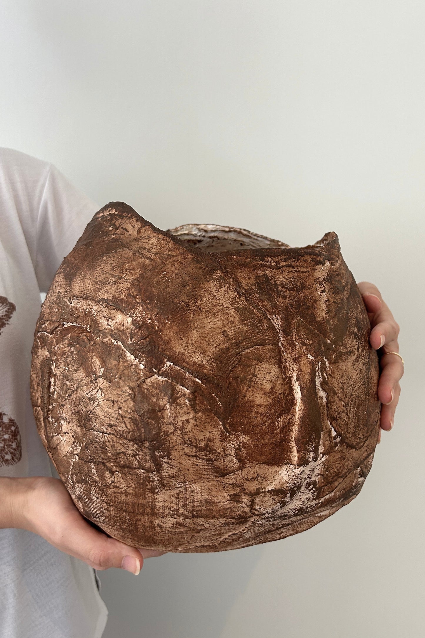 Earthy vase captured in soft natural light, highlighting its unique sculptural details and hand-painted layers.